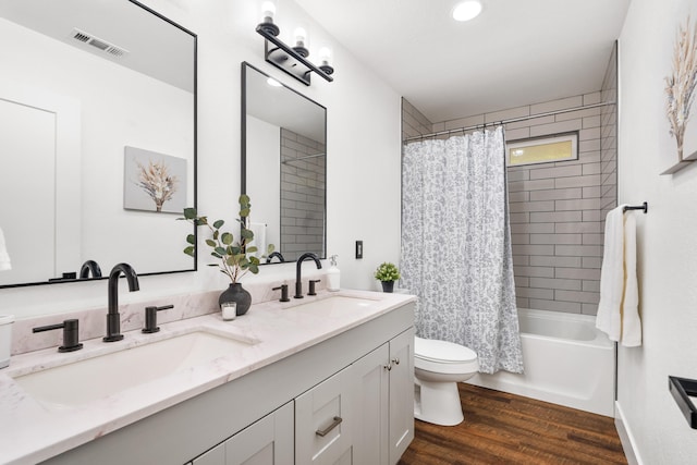 full bathroom with shower / tub combo with curtain, vanity, hardwood / wood-style flooring, and toilet