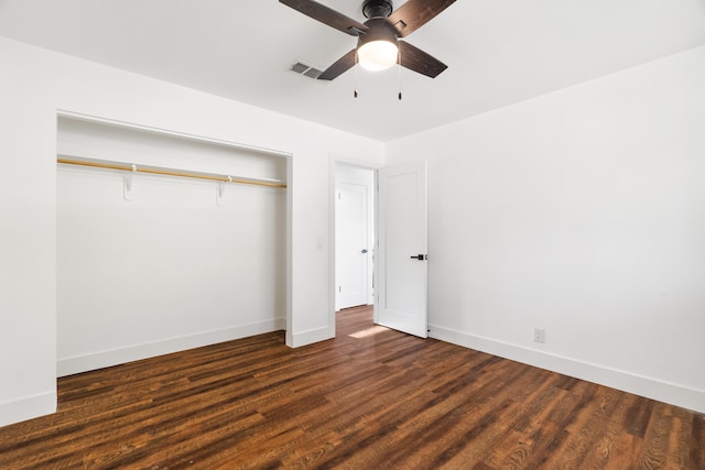 unfurnished bedroom featuring dark wood-type flooring, a closet, and ceiling fan