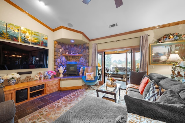 living room with lofted ceiling, crown molding, a wood stove, and ceiling fan