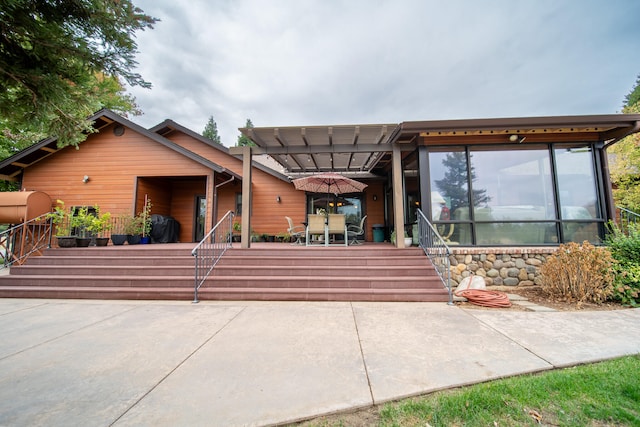 view of front of property featuring a patio and a pergola