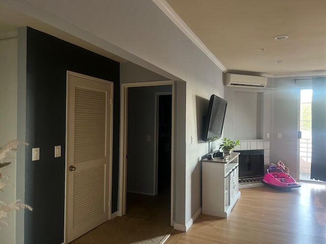 hallway featuring light hardwood / wood-style floors, an AC wall unit, and ornamental molding