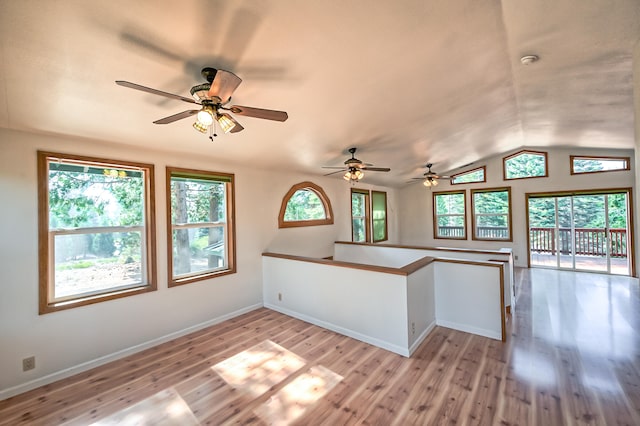 kitchen featuring lofted ceiling, light hardwood / wood-style floors, and plenty of natural light