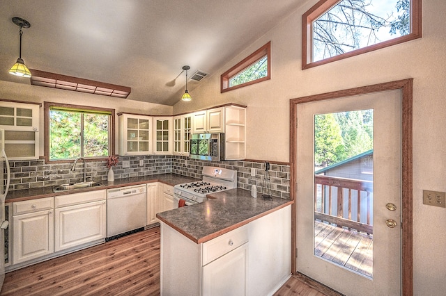 kitchen with white appliances, sink, light wood-type flooring, hanging light fixtures, and white cabinetry