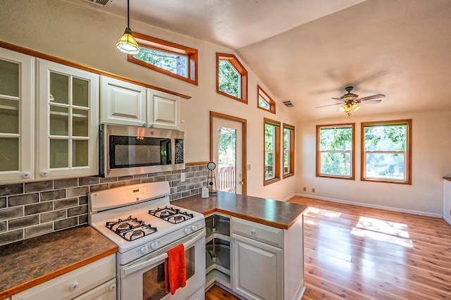 kitchen with kitchen peninsula, white range with gas stovetop, lofted ceiling, white cabinets, and light hardwood / wood-style flooring