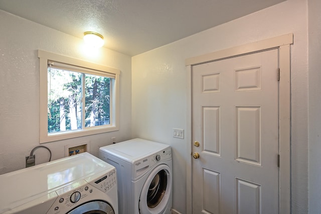 laundry area with a textured ceiling and washing machine and clothes dryer