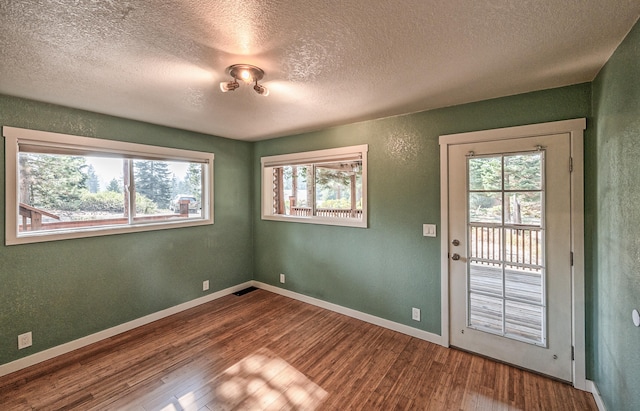 entryway with a textured ceiling and wood-type flooring