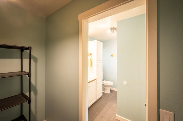 bathroom with toilet, vanity, and tile patterned floors