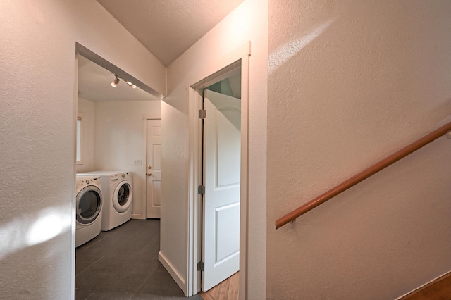 washroom with dark tile patterned floors and washing machine and clothes dryer