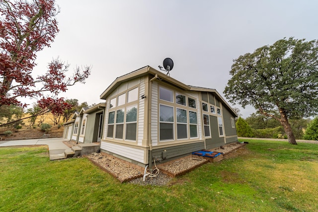 view of side of home with a yard