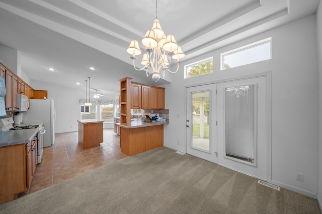 kitchen with kitchen peninsula, light colored carpet, decorative light fixtures, and white appliances