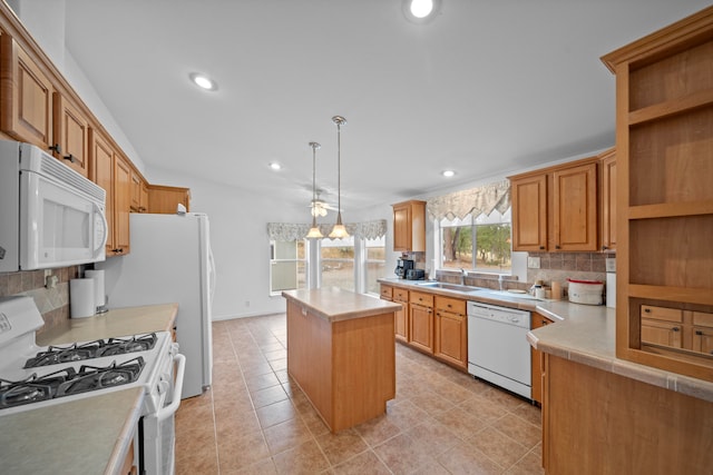 kitchen with tasteful backsplash, a kitchen island, decorative light fixtures, sink, and white appliances