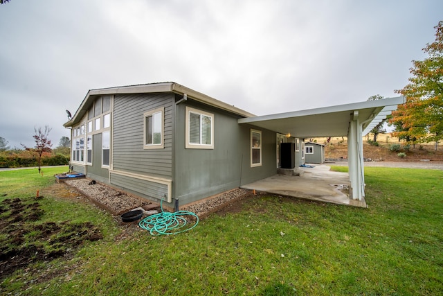 back of house featuring a lawn and a patio area