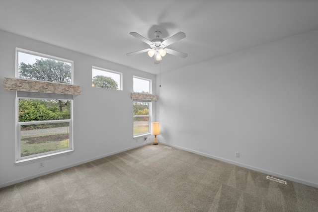 unfurnished room with ceiling fan, a healthy amount of sunlight, and carpet