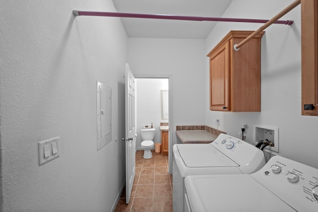 laundry area with cabinets, washing machine and dryer, light tile patterned floors, and electric panel