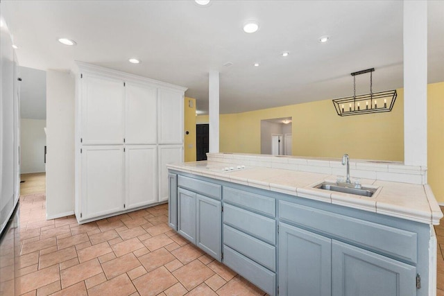 15540 China Rapids Dr, Red Bluff, CA 96080 - kitchen featuring a sink, white cabinets, pendant lighting, tile countertops, and a peninsula