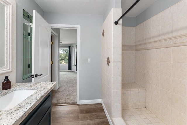 bathroom with vanity, hardwood / wood-style floors, and tiled shower