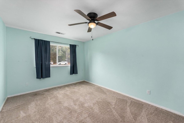 empty room featuring ceiling fan and carpet