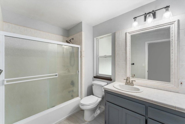 full bathroom featuring vanity, toilet, and enclosed tub / shower combo