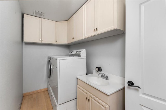 15540 China Rapids Dr, Red Bluff, CA 96080 - laundry room featuring washer and clothes dryer, cabinet space, light wood-type flooring, and baseboards