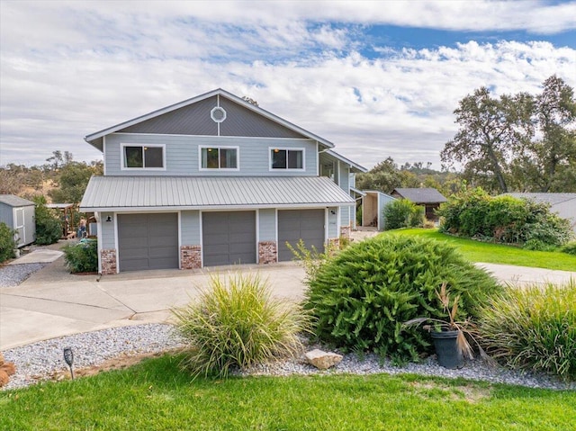 15540 China Rapids Dr, Red Bluff, CA 96080 - view of front of house featuring an attached garage, driveway, metal roof, and brick siding