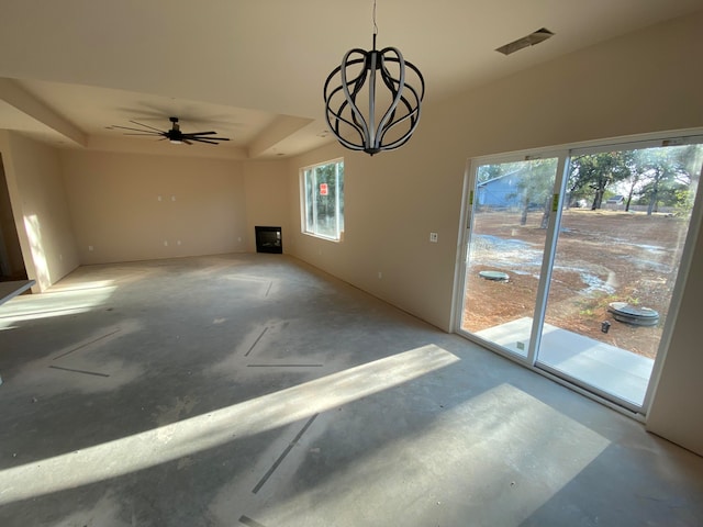 dining room with a wealth of natural light, ceiling fan with notable chandelier, and concrete floors