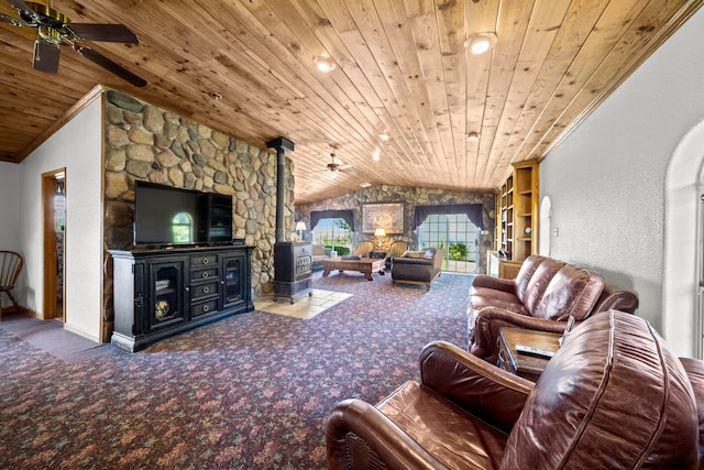 carpeted living room featuring ceiling fan, a wood stove, vaulted ceiling, and wooden ceiling