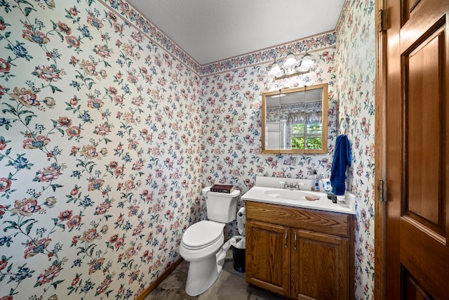 bathroom with vanity, toilet, and a textured ceiling