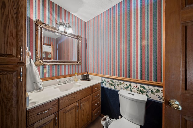 bathroom featuring vanity, toilet, and a textured ceiling