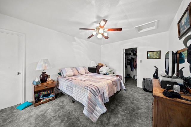 carpeted bedroom featuring a spacious closet, ceiling fan, a closet, and a textured ceiling