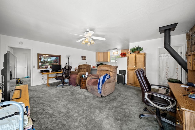 carpeted home office featuring a textured ceiling, a wood stove, and ceiling fan