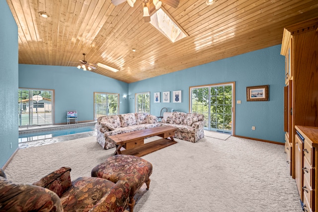 living room featuring lofted ceiling with skylight, wood ceiling, light colored carpet, and ceiling fan