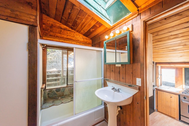 bathroom with lofted ceiling with skylight, wood ceiling, wooden walls, and hardwood / wood-style floors