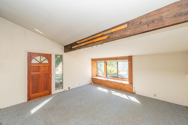 carpeted foyer featuring vaulted ceiling with beams