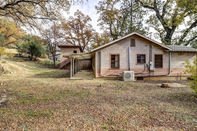 rear view of house with a carport and ac unit