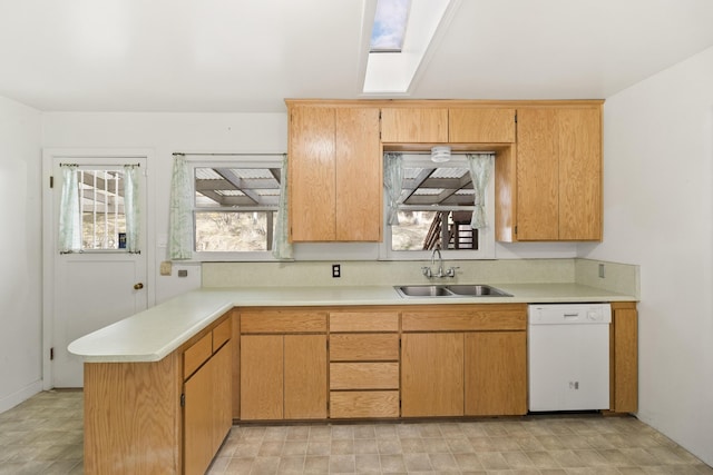 kitchen featuring dishwasher, kitchen peninsula, sink, and a skylight