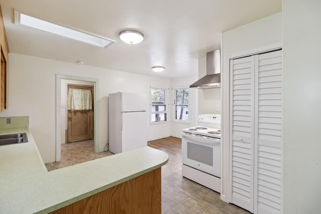 kitchen featuring white appliances, wall chimney exhaust hood, and sink