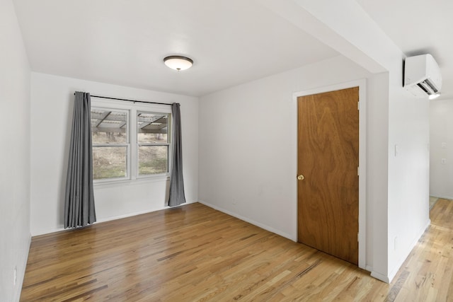 empty room with light hardwood / wood-style flooring and a wall mounted AC