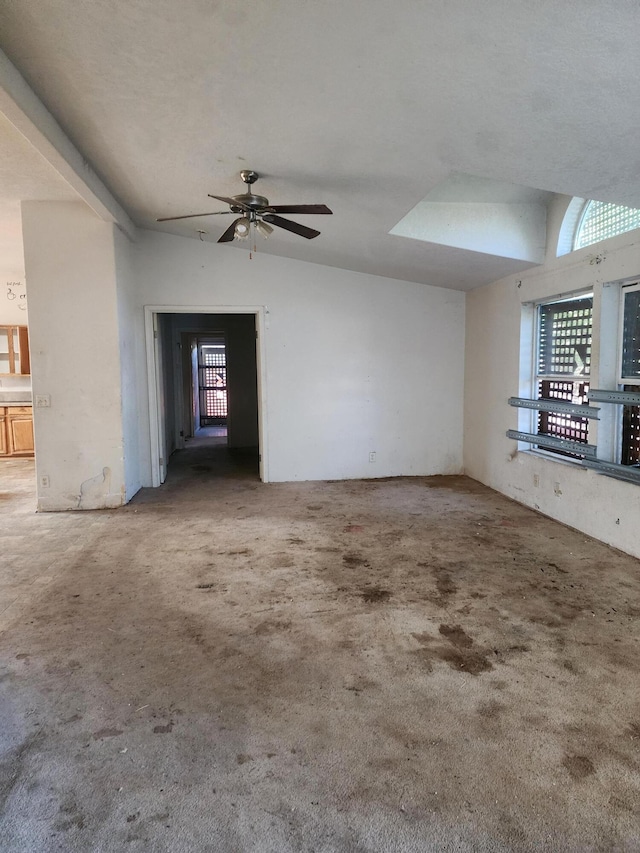 carpeted spare room with lofted ceiling, plenty of natural light, and ceiling fan