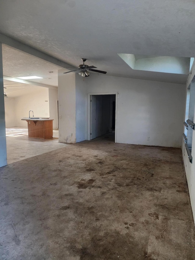 unfurnished room featuring lofted ceiling, a textured ceiling, and ceiling fan