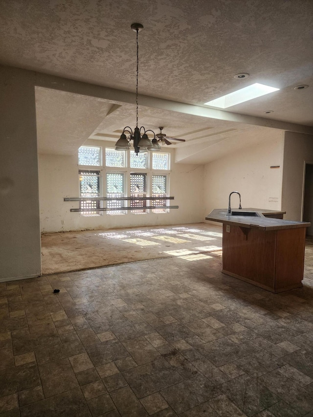 unfurnished dining area featuring sink, a textured ceiling, and ceiling fan