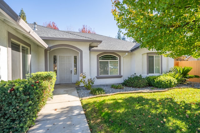 doorway to property with a lawn