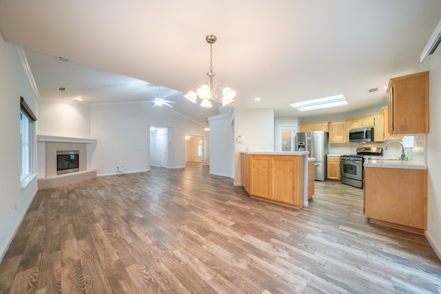 kitchen featuring appliances with stainless steel finishes, light hardwood / wood-style flooring, hanging light fixtures, and crown molding