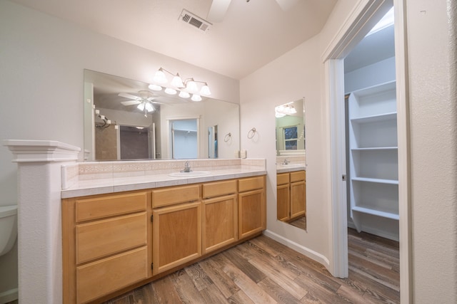 bathroom with hardwood / wood-style floors, vanity, an enclosed shower, and toilet