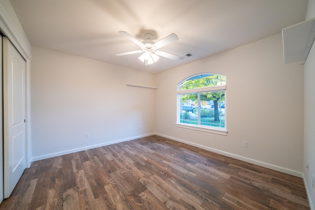 spare room with dark hardwood / wood-style flooring and ceiling fan