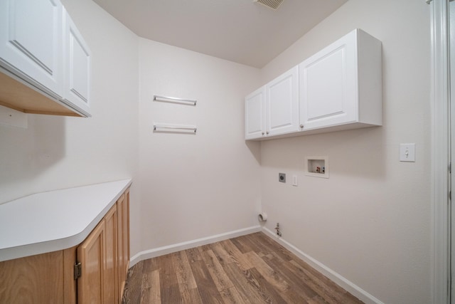 washroom featuring gas dryer hookup, cabinets, hookup for a washing machine, light wood-type flooring, and hookup for an electric dryer