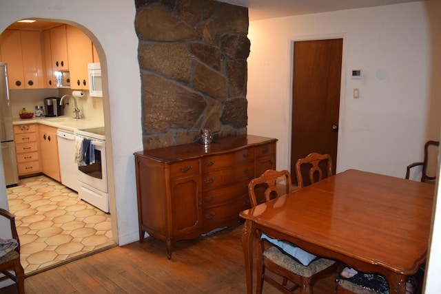 kitchen with backsplash, light hardwood / wood-style floors, white appliances, and sink