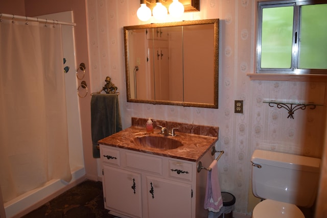 bathroom featuring a shower with shower curtain, vanity, and toilet