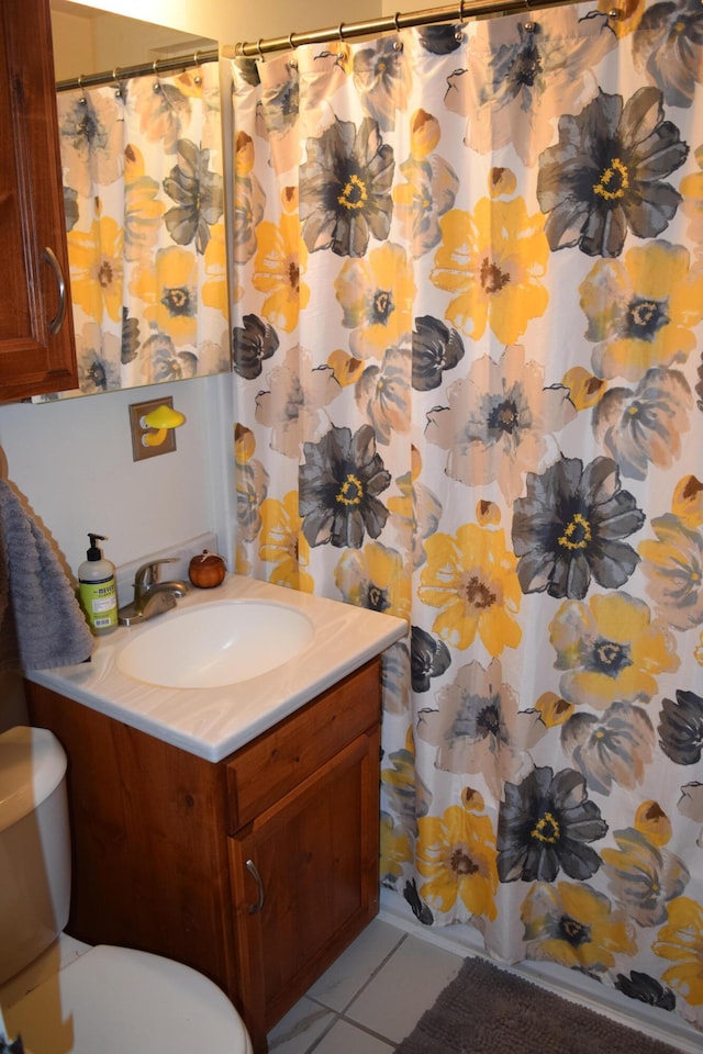 bathroom featuring walk in shower, tile patterned flooring, vanity, and toilet