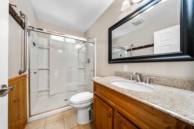 bathroom featuring vanity, a shower with shower door, tile patterned flooring, and toilet