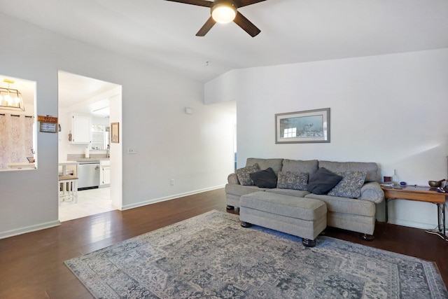 living room with light hardwood / wood-style flooring, vaulted ceiling, and ceiling fan